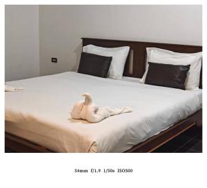 Ein ausgestopfter Vogel liegt auf einem Bett in der Unterkunft king s hotel in Mae Sot