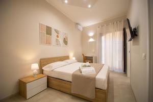 a bedroom with a large white bed and a window at Athenèa Smart Rooms - Atenea Collection in Agrigento