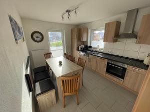 a kitchen with a table and chairs and a clock at Am Wangermeer 14 in Wangerland