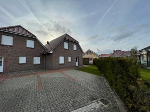 a large brick house with a brick driveway at Am Wangermeer 14 in Wangerland