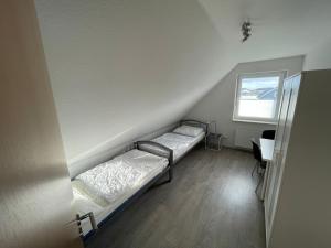 two beds in a room with a desk and a window at Am Wangermeer 14 in Wangerland