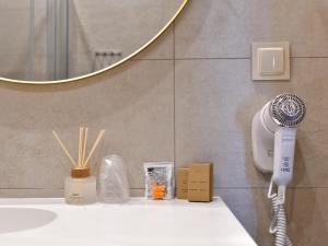 a bathroom with a hair dryer and a mirror at Oysters & Bubbles Gastro Rooms Rynek Square in Poznań