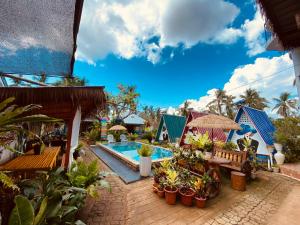 a resort with a swimming pool and some plants at La Provinzia Exclusive Use - 3 Air-Conditioned Rooms 3 Fan Cooled Huts Good for 12 People in Camotes Islands