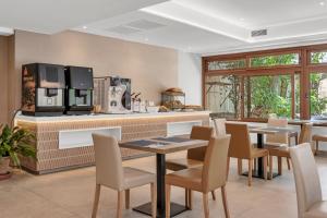 a dining room with tables and chairs and a kitchen at Hotel Castell dels Hams in Porto Cristo