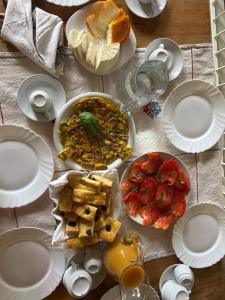 a table with white plates and food on it at B&B Casa CamiLory in San Lucido