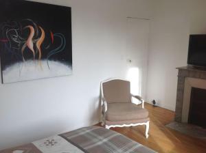 a living room with a chair and a fireplace at Maîson Vigneronne in Nazelles