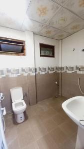 a bathroom with a toilet and a sink at Kamaleswari Villa Trincomalee in Trincomalee +37 photos