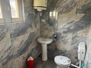 a bathroom with a toilet and a sink at Samoon Guest House in Karnāl