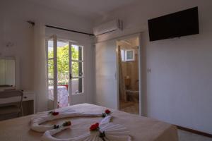 a bedroom with a bed with flowers on it at Lisipio Studios by Eleni in Paleokastritsa