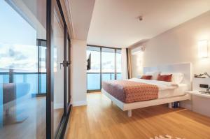a bedroom with a bed and a large window at Panorama Batumi Black Sea View in Batumi +103 photos