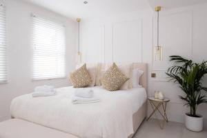 a white bedroom with a bed with towels on it at Beeches Retreat in Shrewsbury