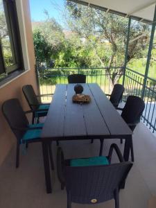 a wooden table and chairs on a porch at Arethousa House in Nea Vrasna
