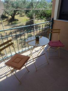 a table and two chairs on a balcony at Arethousa House in Nea Vrasna