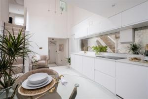 a kitchen with white cabinets and a glass table at Beeches Retreat in Shrewsbury