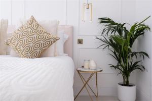 a bedroom with a white bed and a plant at Beeches Retreat in Shrewsbury +8 photos