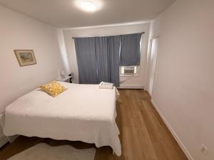 a small bedroom with a white bed and a window at Spacious 2BR Getaway Easy Access to NYC & Newark in Kearny