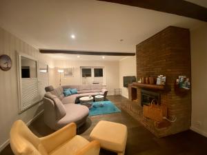 a living room with a couch and a fireplace at Haus Rosenwind in Wangerland