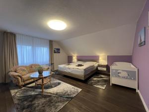 a bedroom with a bed and a couch and a table at Haus Rosenwind in Wangerland