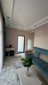 a living room with a green couch and a table at Comfort Point Hotel in Bishkek