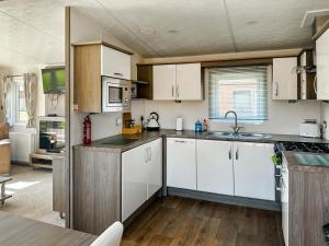a kitchen with white cabinets and a sink at Aquila - Uk49467 in Morpeth