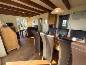 a dining room and living room with a table and chairs at Minser Deichhaus in Wangerland