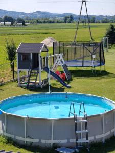 a large pool with a slide and a playground at Domek na Dogalu in Filipowice