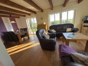a living room with leather furniture and a table at Minser Deichhaus in Wangerland