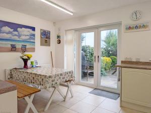 a dining room with a table and a sliding glass door at 2 Seafield Terrace, Bognor Regis in Bognor Regis