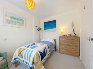 a bedroom with a bed and a wooden dresser at 2 Seafield Terrace, Bognor Regis in Bognor Regis