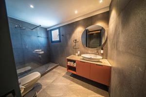 a bathroom with a sink and a mirror and a toilet at Sky Suites Nicosia in Strovolos +52 photos
