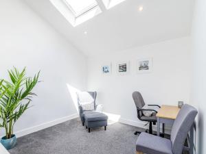 a waiting room with chairs and a table and a plant at High Trees View in Knaresborough