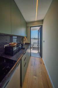 a kitchen with green cabinets and a view of the ocean at Sky Suites Nicosia in Strovolos