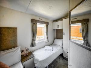 a small bedroom with two beds and a mirror at Phoenix - Uk49470 in Morpeth