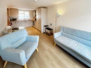a living room with a blue couch and a table at Castleriggs Cottage - Uk45178 in Threlkeld