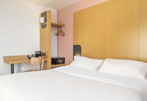 a bedroom with a white bed and a desk at B&B HOTEL Martigues Port-de-Bouc in Port-de-Bouc