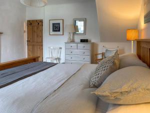 a bedroom with a large bed and a dresser at Sea Breeze in Blakeney