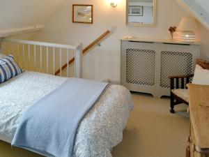 a bedroom with a bed and a stair case at Sea Breeze in Blakeney