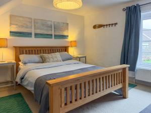 a bedroom with a bed and two lamps and a window at Sea Breeze in Blakeney