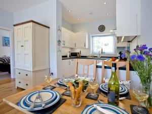 a kitchen with a table with plates and wine glasses at Dunlin 4 - The Cove in Brixham