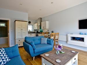 a living room with a blue couch and a table at Dunlin 4 - The Cove in Brixham