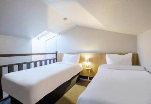 a room with two beds and a window at B&B HOTEL FREJUS Puget-sur-Argens in Fréjus