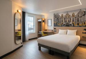 a hotel room with a bed and a mirror at B&B HOTEL Orléans Centre Foch in Orléans
