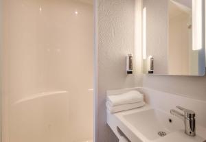 a white bathroom with a sink and a shower at B&B HOTEL Antibes Sophia Antipolis in Biot