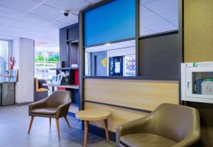 a waiting room with two chairs and a table at B&B HOTEL Antibes Sophia Antipolis in Biot