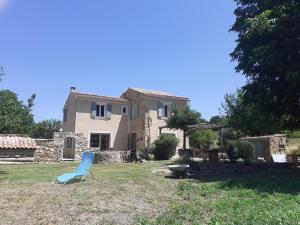 a blue lawn chair in front of a house at Le pavillon in Aubignan