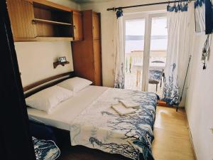 a small bedroom with a bed and a window at CHEAPEST APARTMENTS WITH PANORAMIC SEA VIEW CLOSE SANDY BEACH CRIKVENICA about 150m to sea in Crikvenica