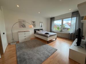 a bedroom with a bed and a television and a window at FeWo am Baunsberg in Baunatal