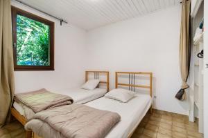 two beds in a room with a window at 1.Chataigniers option clim- 4pers in Calviac