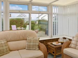 a living room with a couch and chairs and windows at Turnstones in Walcott +9 photos