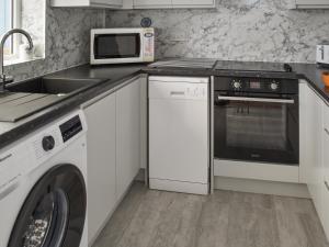 a kitchen with a washer and dryer and a microwave at Turnstones in Walcott